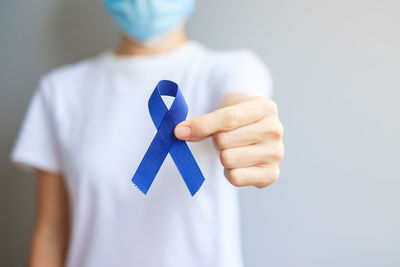 Midsection of woman holding gift against white background