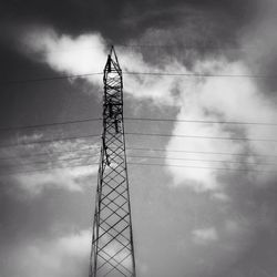 Low angle view of power lines against cloudy sky