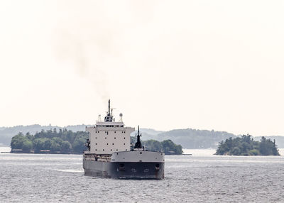 Ship sailing in sea against clear sky