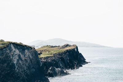 Scenic view of sea and mountains against clear sky