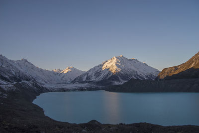 Glacier scenic view of lake and snowcapped mountains against clear sky