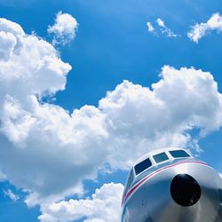 Low angle view of airplane flying against blue sky