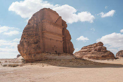 Rock formations on beach against sky