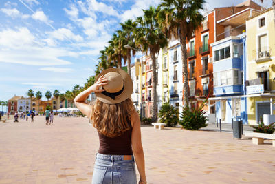 Happy traveler girl visiting the colorful spanish village villajoyosa, alicante, spain