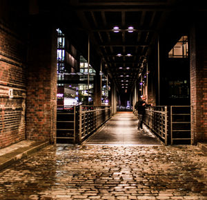 Illuminated corridor in city at night