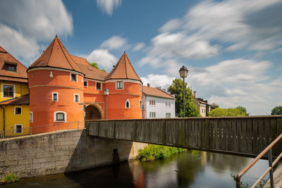 Bridge over river amidst buildings against sky