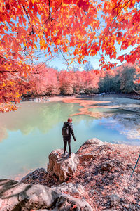 Man standing by lake during autumn