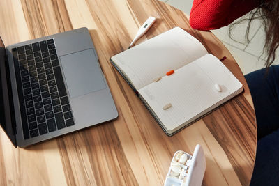 High angle view of laptop and book on table