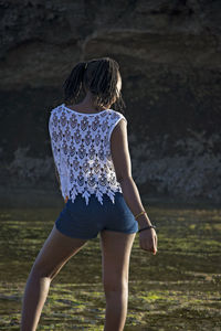 Rear view of woman standing on field