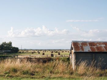 Scenic view of field against cloudy sky