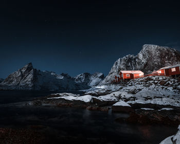 Snow covered mountains against sky at night