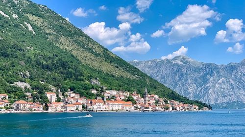 Scenic view of sea by townscape against sky