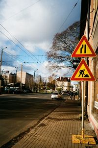 Road sign against sky in city