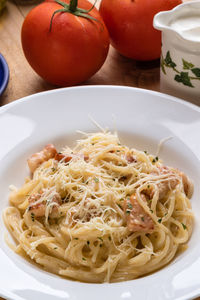 High angle view of spaghetti with carbonara in plate on table