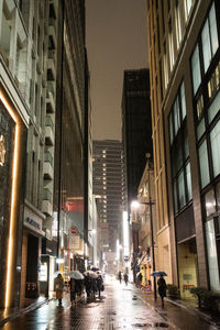 Street amidst buildings in city at night