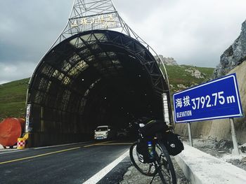 Rear view of bicycle on road against sky