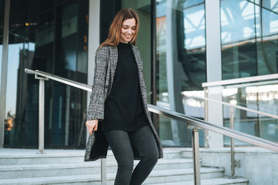 Portrait of young woman standing in city