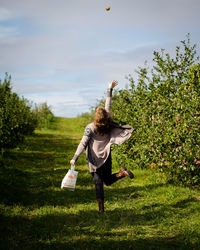 Full length of young woman at apple orchard