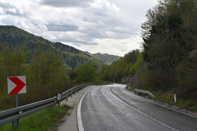 Road amidst trees against sky