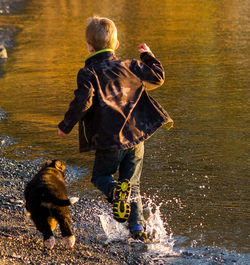 Rear view of man with dog in water