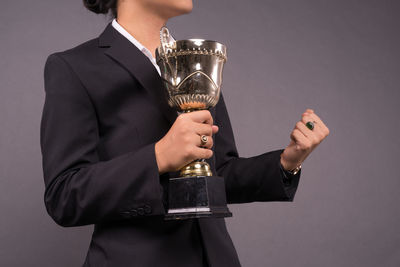 Midsection of a man holding glass