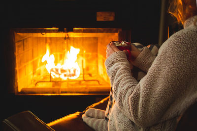 Midsection of woman holding burning fire