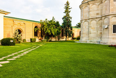 Lawn by building against sky