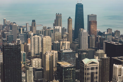 Aerial view of buildings in city against sky