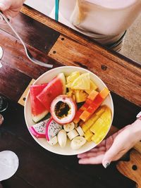 High angle view of woman holding fruits on table
