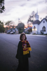 Portrait of girl standing on road against sky