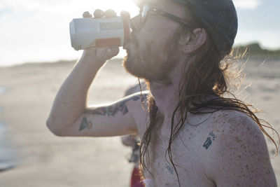 Close-up portrait of mid adult man photographing sea