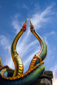  low angle twin stucco painted as a large serpent at pra kai keaw wang nakin,  udon thani, thailand.