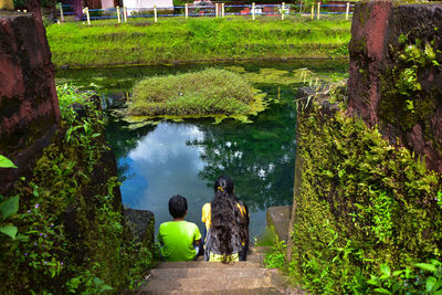 Rear view of woman standing by lake