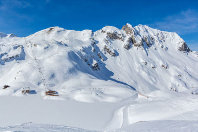 Scenic view of snowcapped mountain against blue sky