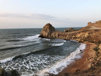 Scenic view of rocks on beach against sky