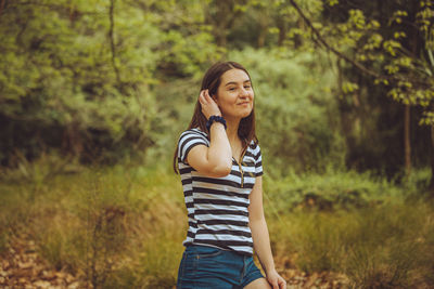 Smiling young woman standing on field