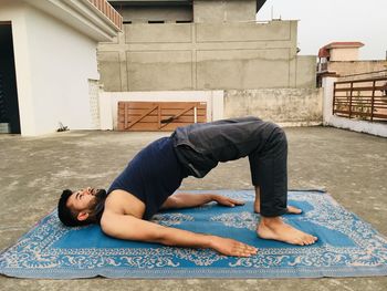 Side view of man exercising in balcony