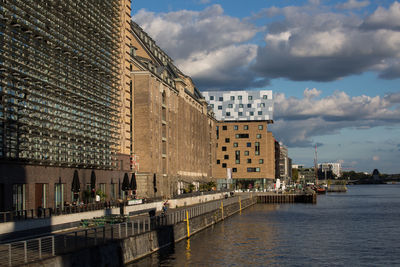 View of buildings in city against cloudy sky