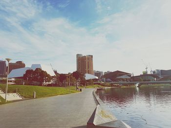 Scenic view of city by sea against sky