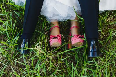 Low section of couple standing on field