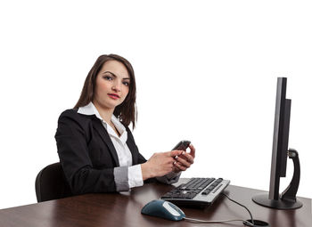 Young woman using mobile phone on table