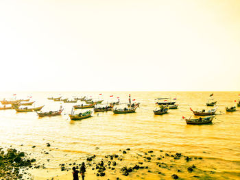 Boats moored on sea against clear sky