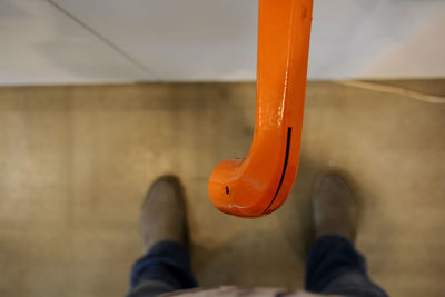 Low section of person against orange wall
