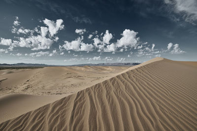 Sand dune in desert against sky