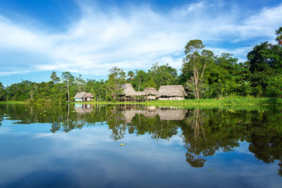 Yanayacu river by houses against cloudy sky