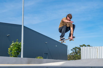 Low angle view of young man jumping on street