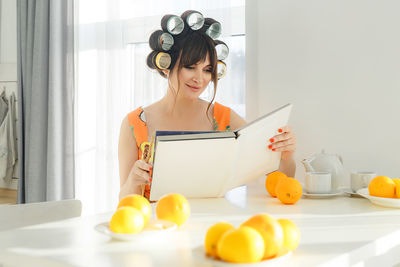 Portrait of smiling young woman using digital tablet at home