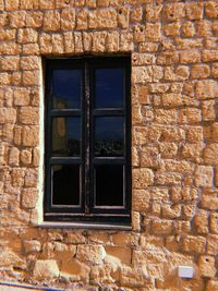 Low angle view of window on brick wall of building