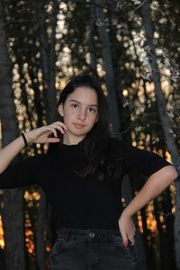 Portrait of teenage girl standing by tree