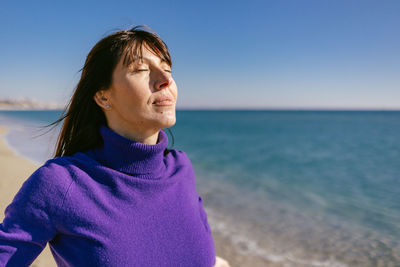 Beautiful happy mature woman enjoying a sunny winter day at the beach